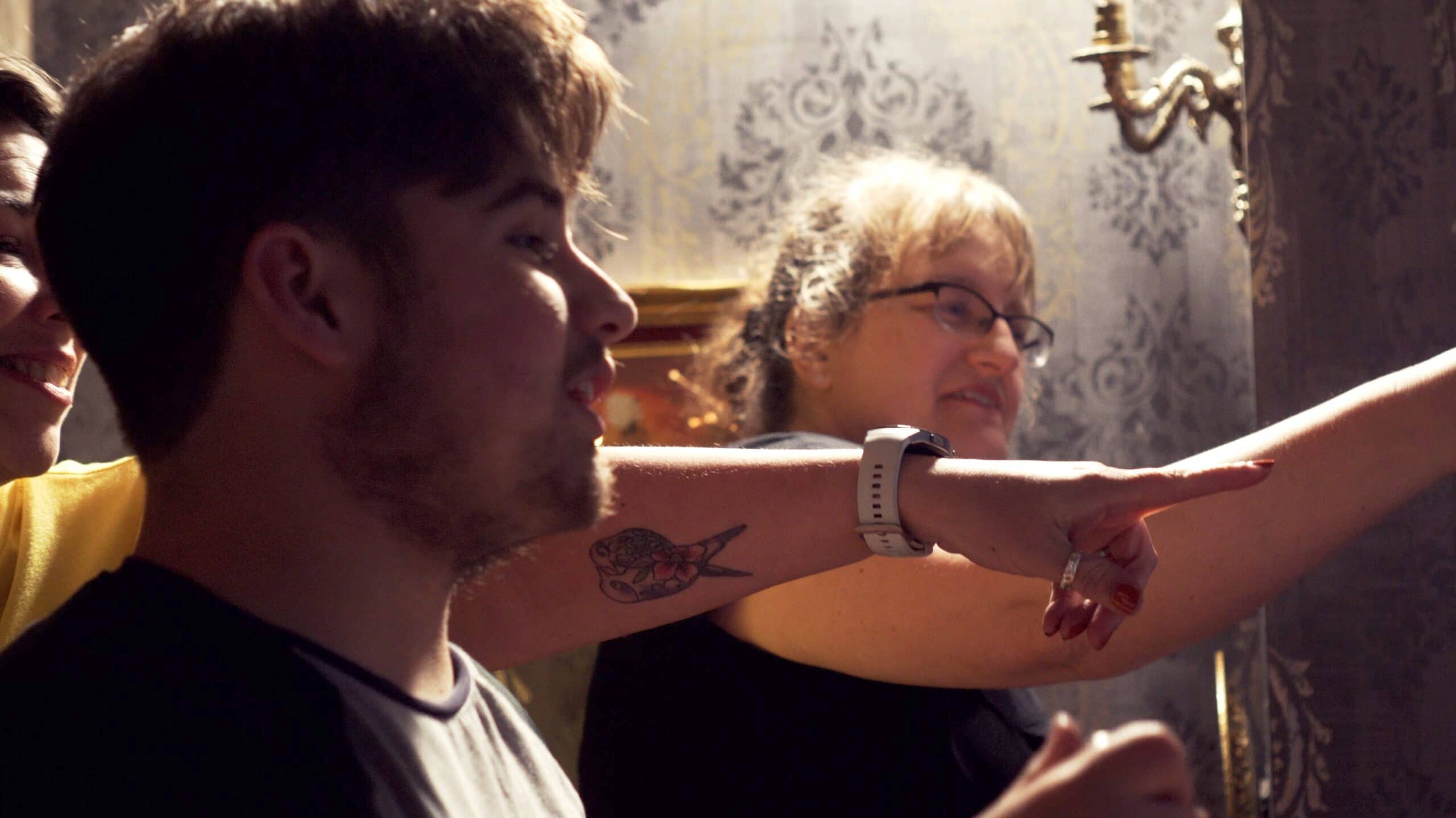 A group of friends playing an escape room game in Llanfyllin and pointing to a clue