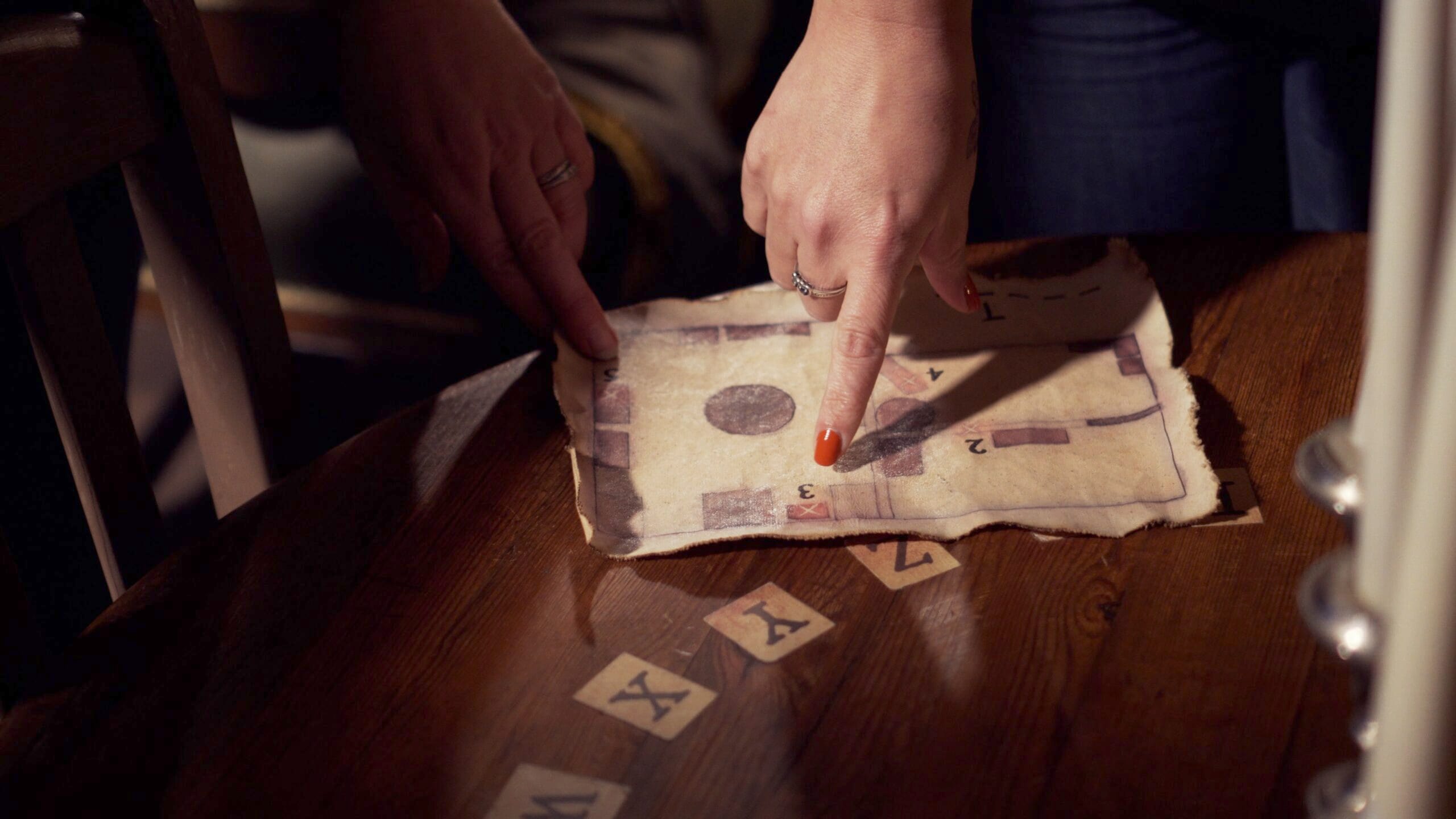 A group of friends playing an escape room and pointing to a clue
