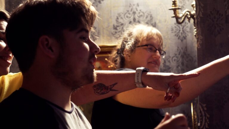 A group of friends playing an escape room game in Llanfyllin and pointing to a clue